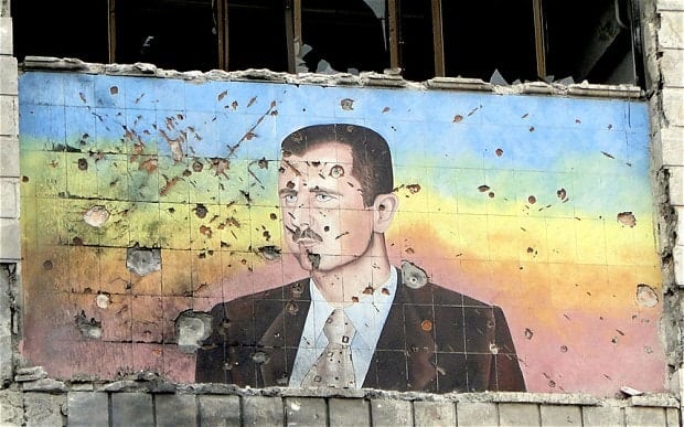 A damaged building with a portrait of Syria's president, a consequence of the Syrian Civil War.
