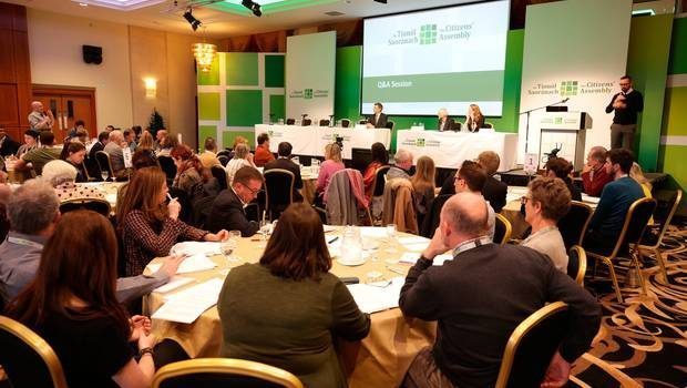 A group of people sitting at a table debating climate change.