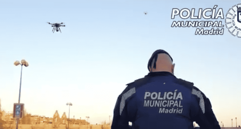 A man in a police uniform is looking at a drone mobilizing for war.
