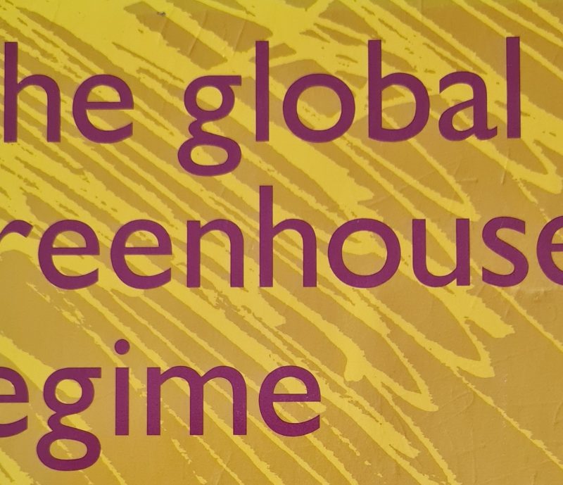 The cover of the 1993 climate book, "The Global Greenhouse Regime," features purple text on a vibrant yellow background adorned with abstract diagonal lines.